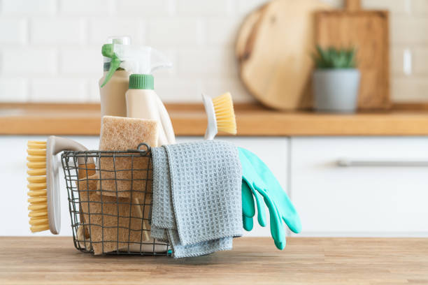 Kitchen cleaning supplies in wire basket with turquoise gloves and gray towels for cleaning services